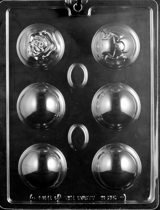 picture of chocolate mold for making hot cocoa bombs or bath bombs. Mold has 6 cavities. 1 of the cavities has an imprint of a rose and 1 cavity has an imprint of a star and moon. The other 4 cavities are plain.