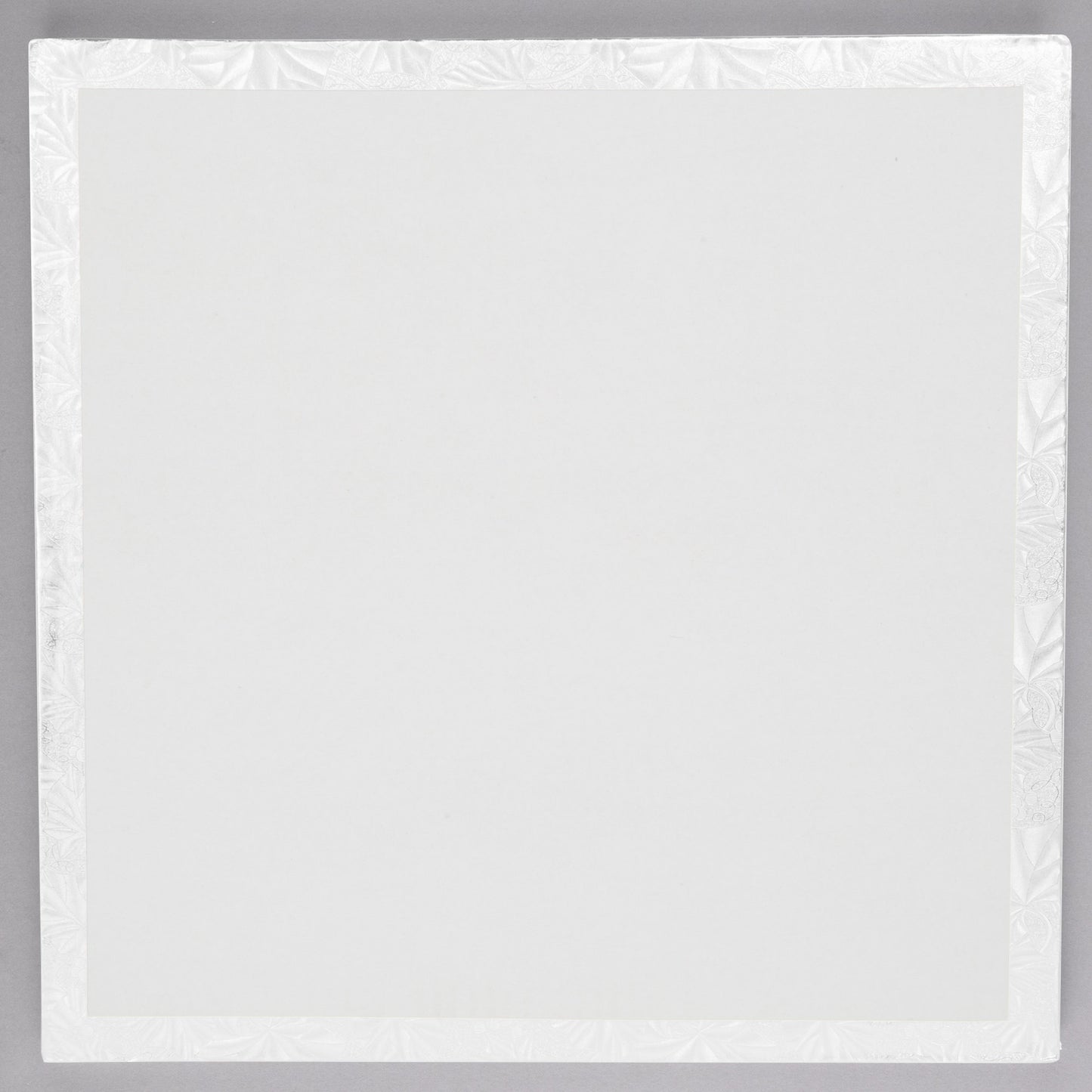 image of the back of a 10 inch square white cake drum that is 1/2 thick