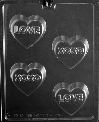 Picture of chocolate mold for making heart-shaped chocolate covered cookies.  This heart shaped mold includes 4 cavities. Two of the cavities have LOVE imprinted on them. Two of the cavities have XOXO imprinted on them.